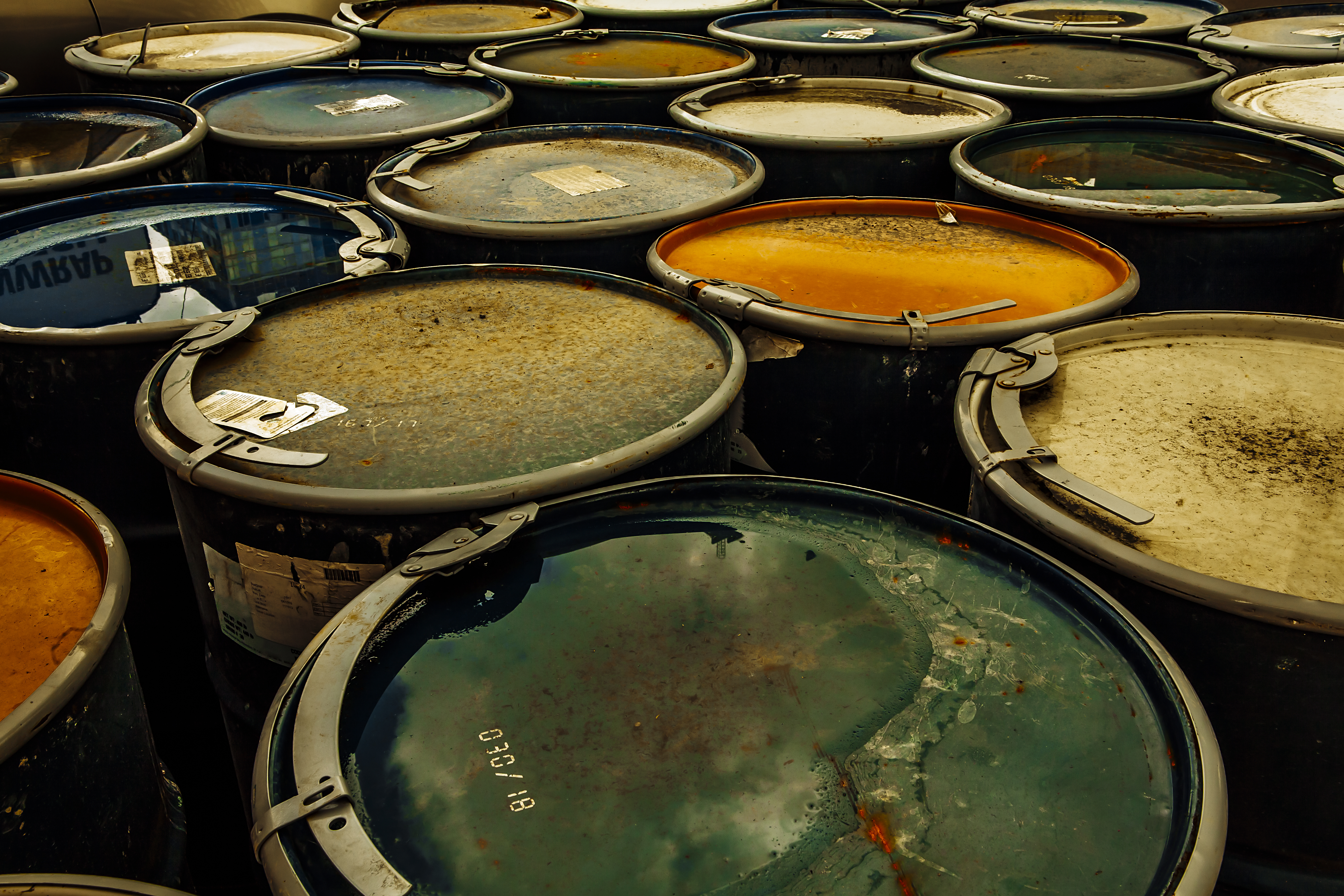 Photo of a group of rusting metal drums.
